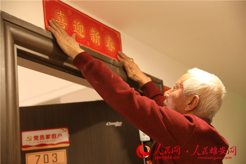 圖為回遷居民為新房貼上春聯。人民網 楊華龍攝