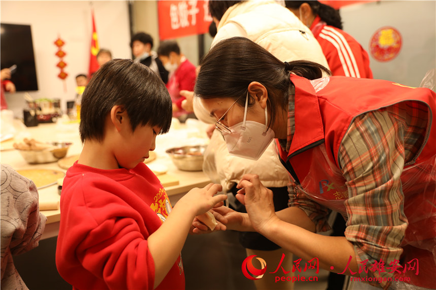 圖為容西片區飛泉社區組織回遷居民包餃子。人民網 楊華龍攝