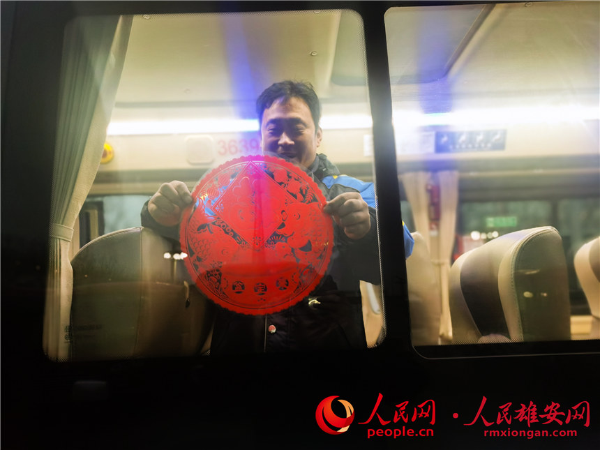 圖為雄安公交司機為公交車貼窗花。河北雄安容暢智慧公共交通有限責任公司供圖