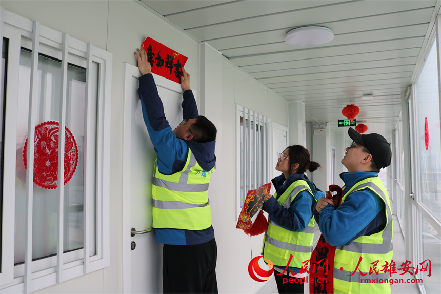 圖為建設者們正在貼對聯。中建三局集團北京有限公司供圖