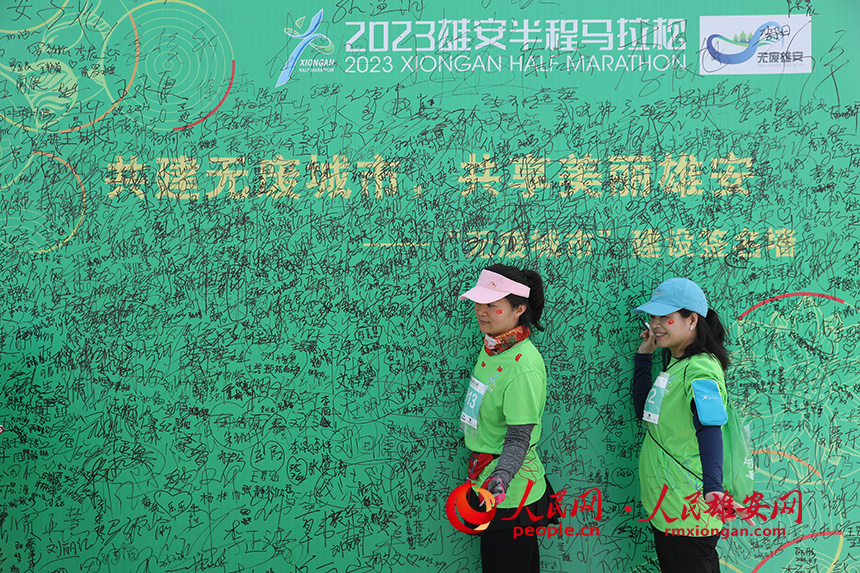 2023雄安半程馬拉松活動現場，雄安新區生態環境局宣傳、倡導無廢城市展板吸引參賽選手一一簽名。人民網 李兆民攝