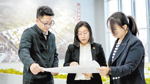 2024年2月，在北京非首都功能疏解中心，夏雨（中）與同事探討項目規劃。受訪者供圖