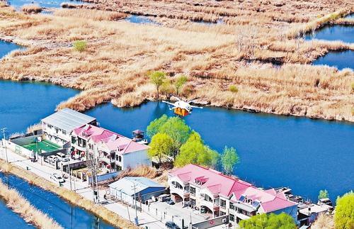 3月21日，中國郵政無人機飛越白洋淀上空，為安新縣圈頭鄉居民配送包裹。 本報記者 張 昊攝